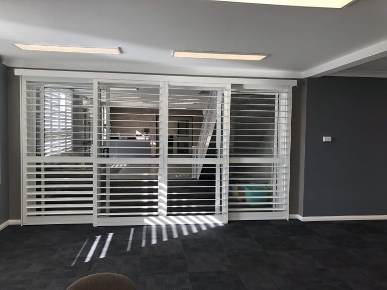 Tracked bi-pass shutters spanning a wide opening